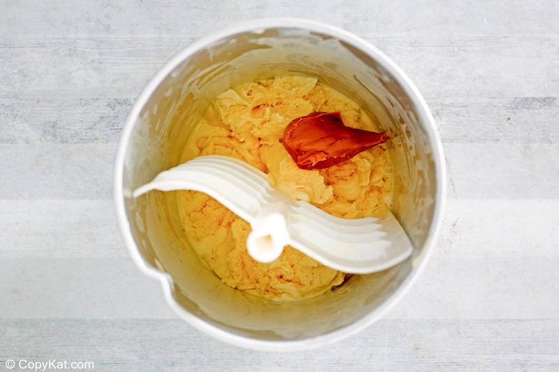 adding peanut butter to ice cream base in an ice cream maker