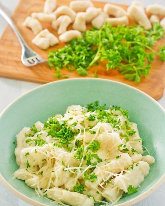 a bowl of homemade potato gnocchi topped with parmesan and parsley