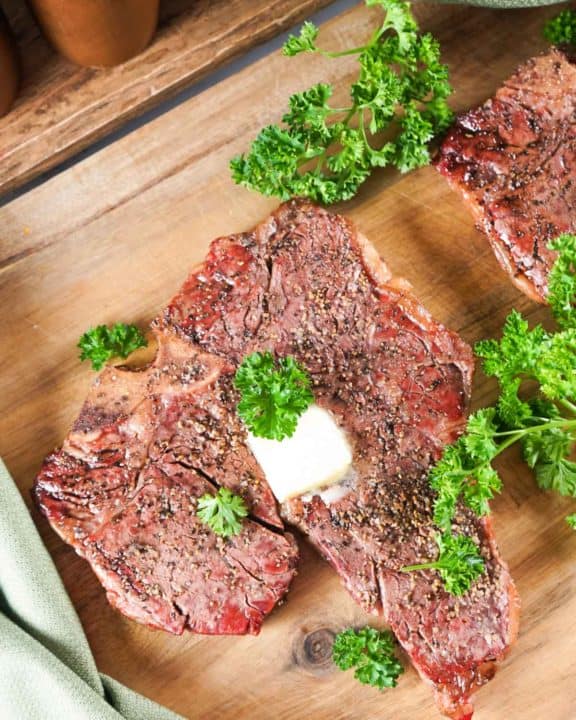smoked steak and fresh parsley on a wood board