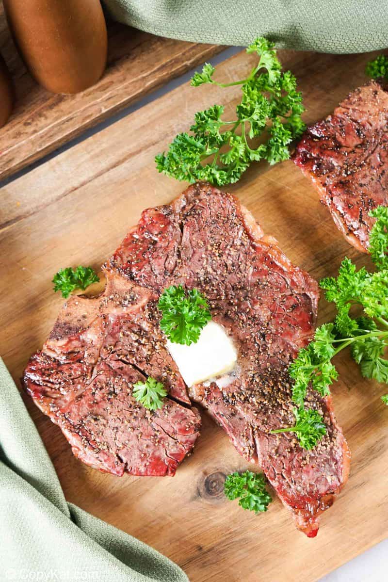 smoked steak and fresh parsley on a wood board