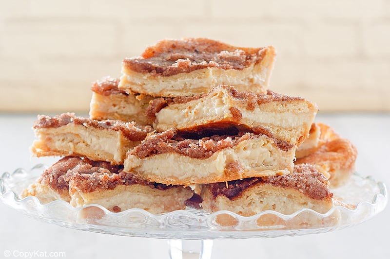 sopapilla cheesecake bars on a cake stand