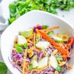 Thai noodle salad in a bowl and Thai basil behind it