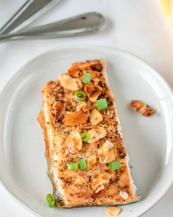 air fried salmon almondine on a white plate