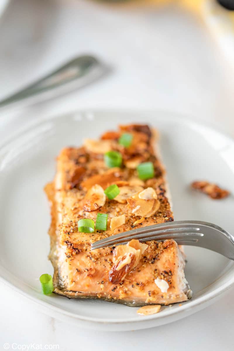 air fried salmon almondine and a fork on a plate