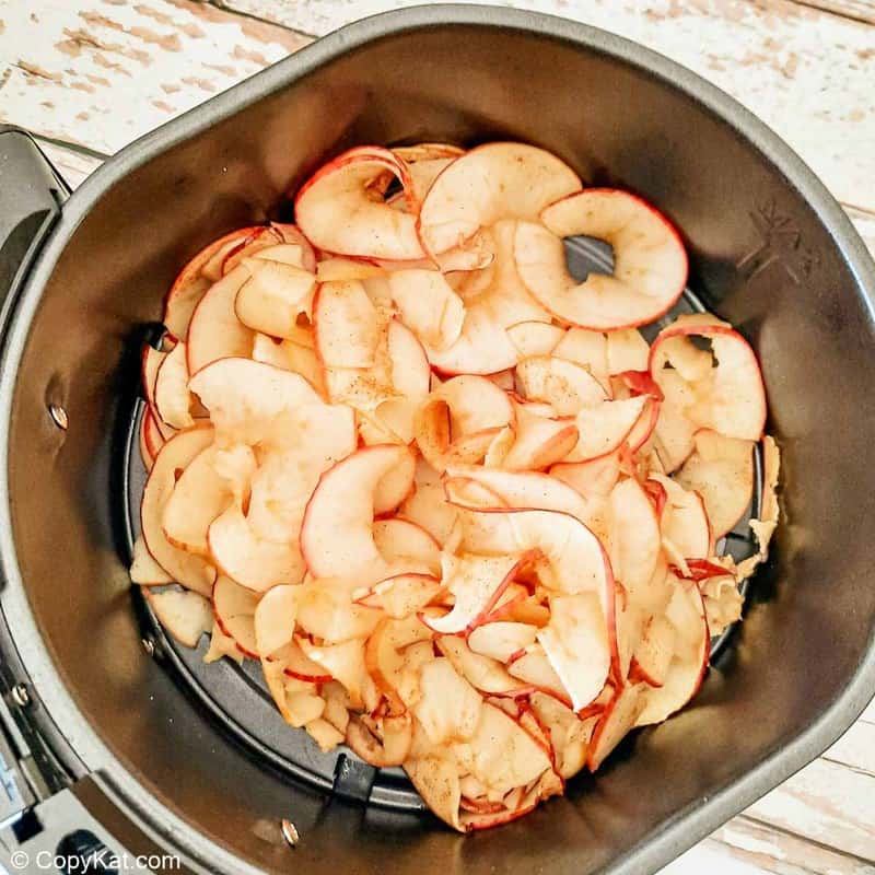 partially air fried apple chips in air fryer basket