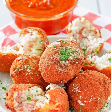 Arancini Italian Rice Balls on a plate and a bowl of marinara sauce