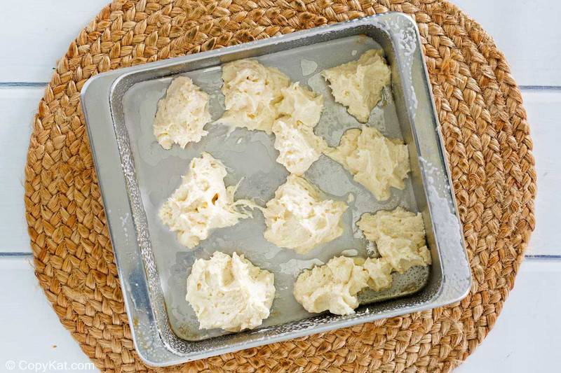 spoonfuls of dough for Bisquick apple cobbler in a baking dish