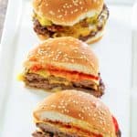 one whole and two halves of homemade Burger King cheeseburger on a platter