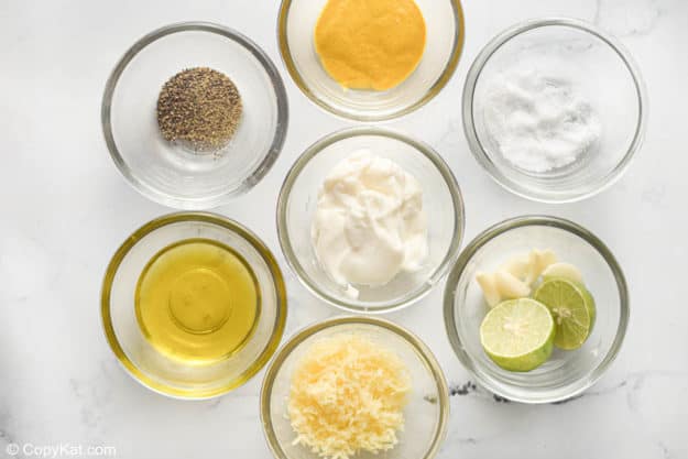 bowls of ingredients for Caesar salad dressing