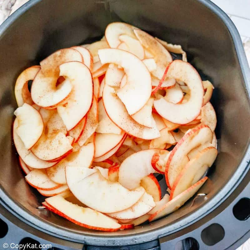 cinnamon sugar apple slices in an air fryer basket