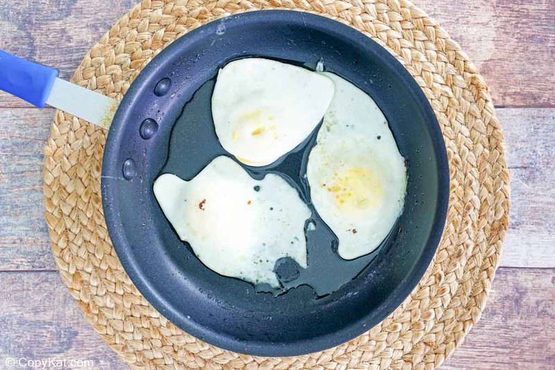 three fried eggs in a skillet