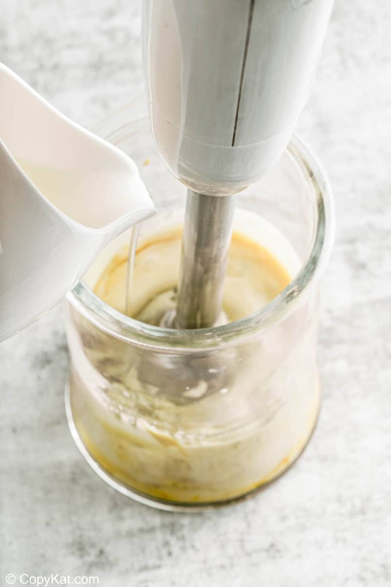 blending oil into mixture for garlic aioli