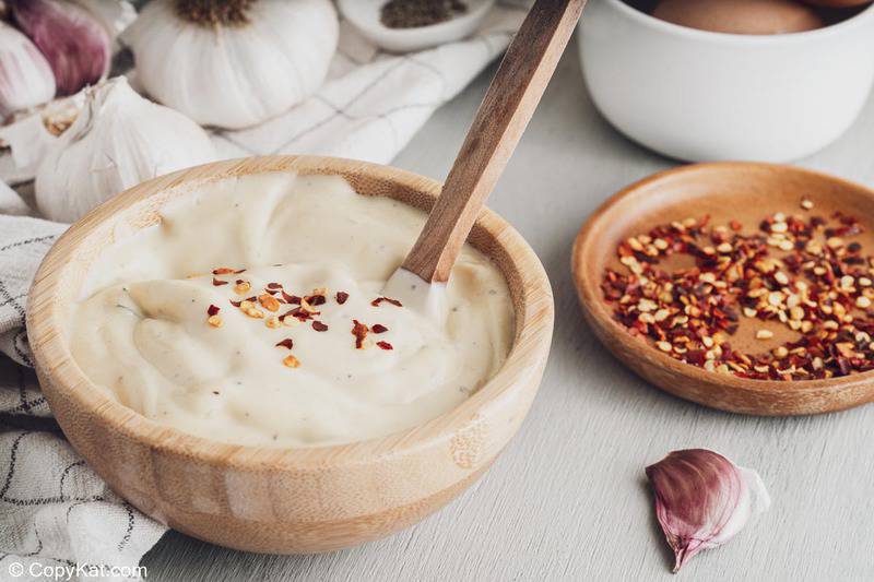 garlic aioli in a bowl and red pepper flakes on a small plate