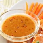 mustard bbq sauce in a bowl, carrot sticks, and hot wings