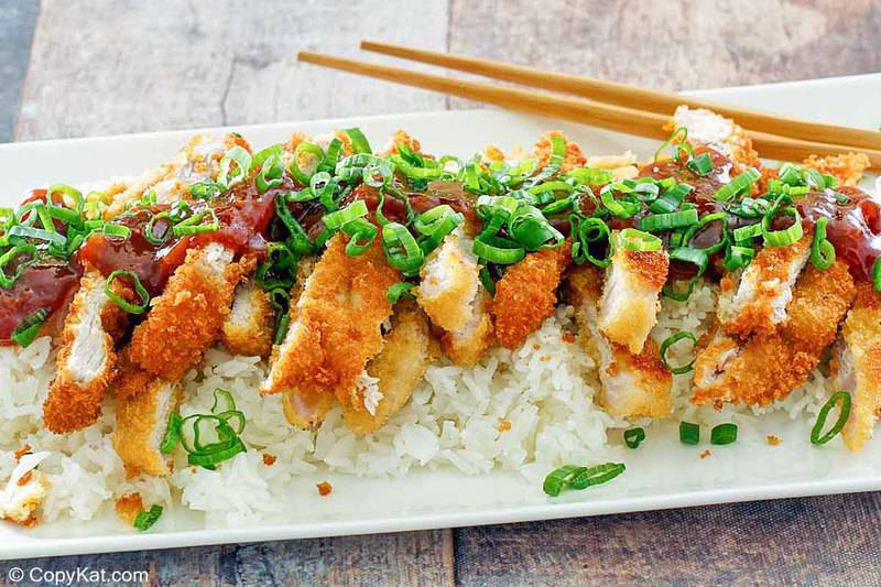pork katsu with tonkatsu sauce over rice on a platter