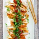 overhead view of pork katsu, tonkatsu sauce, rice, and chopsticks on a platter