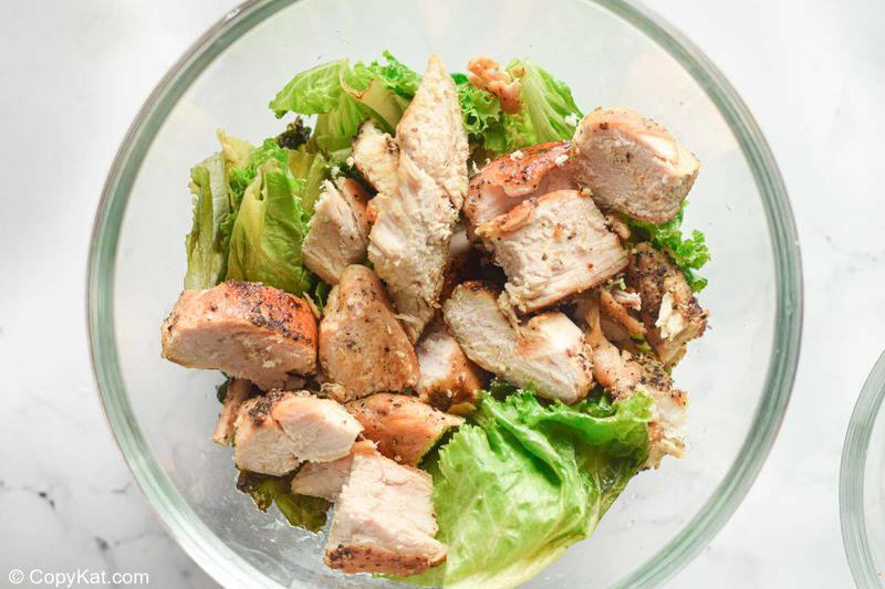 romaine lettuce and chicken pieces in a bowl