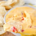 tortilla chip with rotel dip on a bowl of the dip