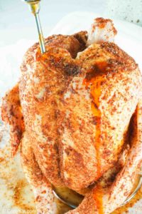 injecting seasoned butter into a chicken