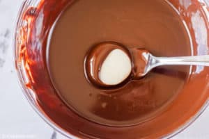 dipping peppermint pattie candy into chocolate