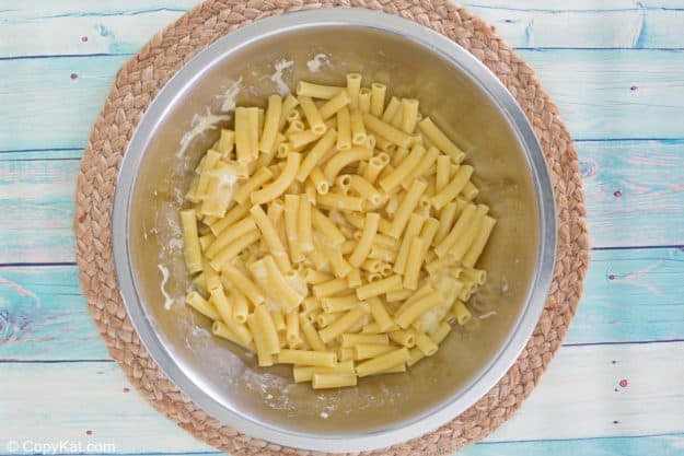 cooked ziti pasta, egg, and parmesan cheese mixture in a bowl