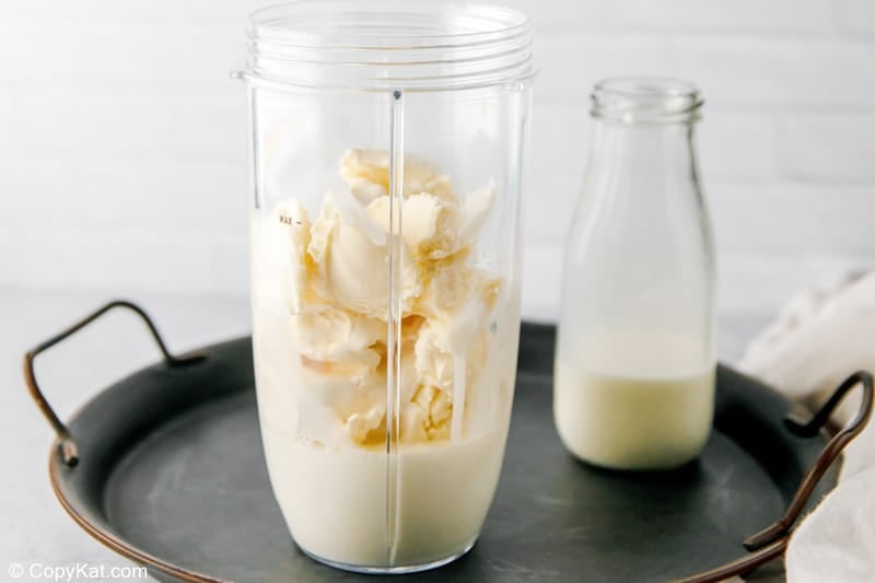 adding half and half into a blender for a banana milkshake