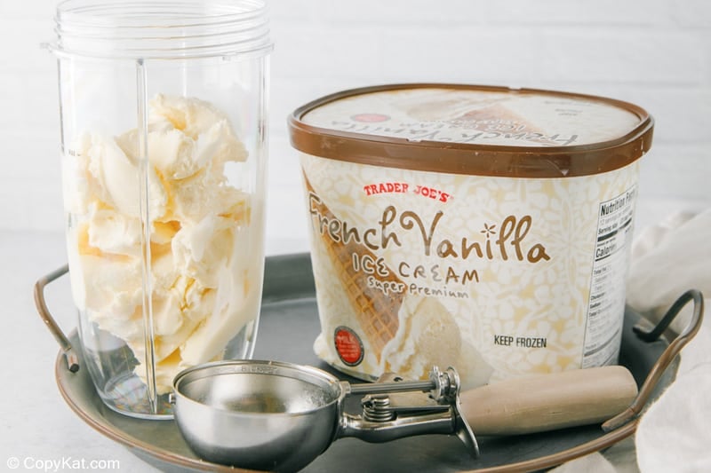 adding ice cream into a blender for a banana milkshake