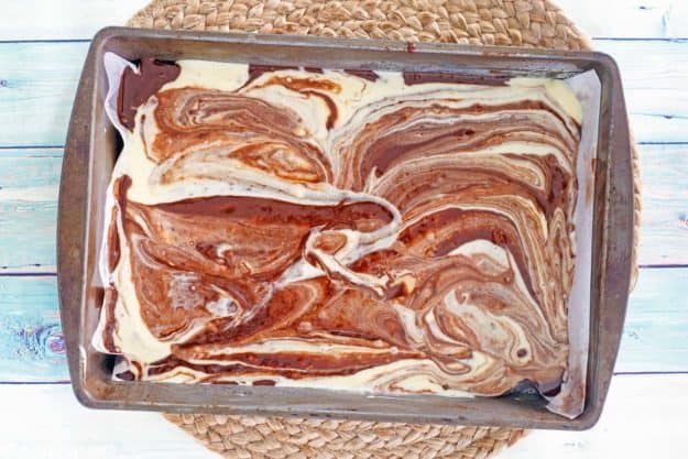 swirled chocolate and cream cheese brownie batter in a baking dish