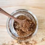 homemade taco seasoning on a spoon on top of a spice jar