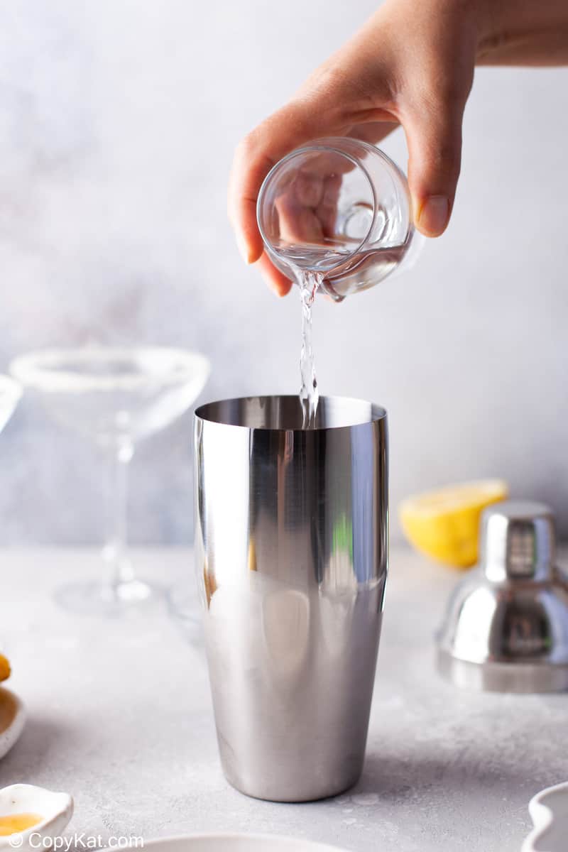 pouring vodka into a cocktail shaker