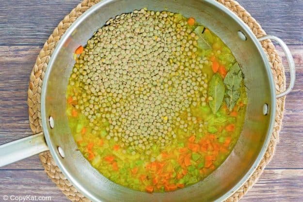 dried lentils, vegetables, chicken stock, and bay leaves in a pan