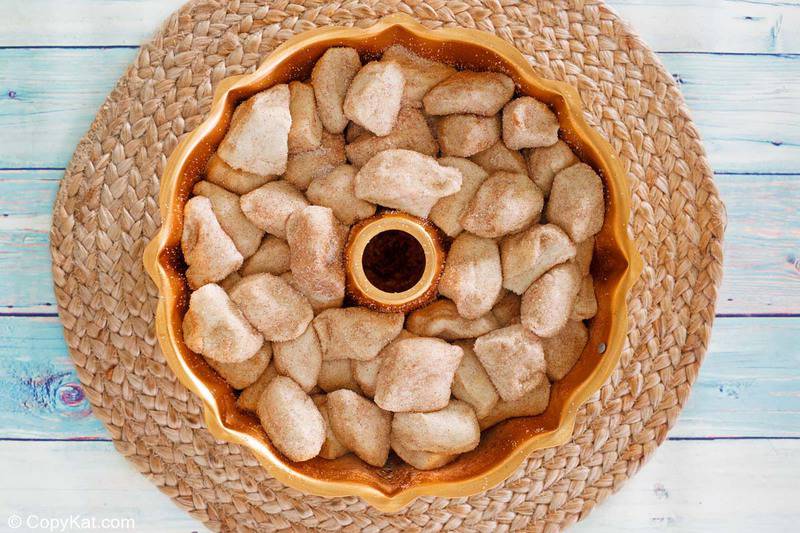 cinnamon sugar coated biscuit pieces in a bundt cake pan