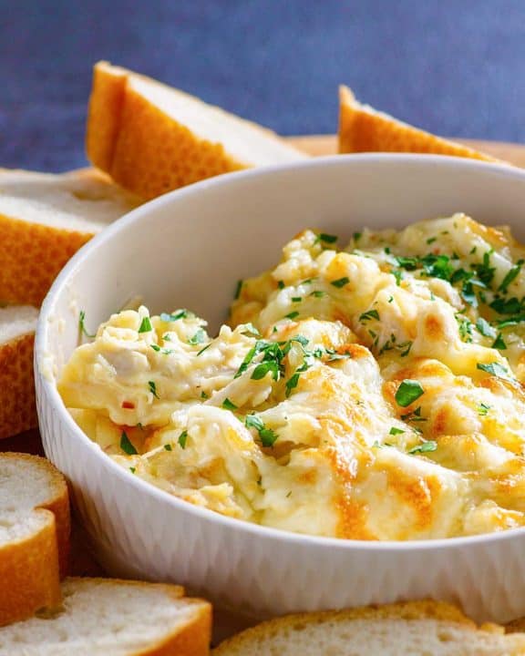 homemade Olive Garden angry alfredo with chicken in a bowl and bread slices
