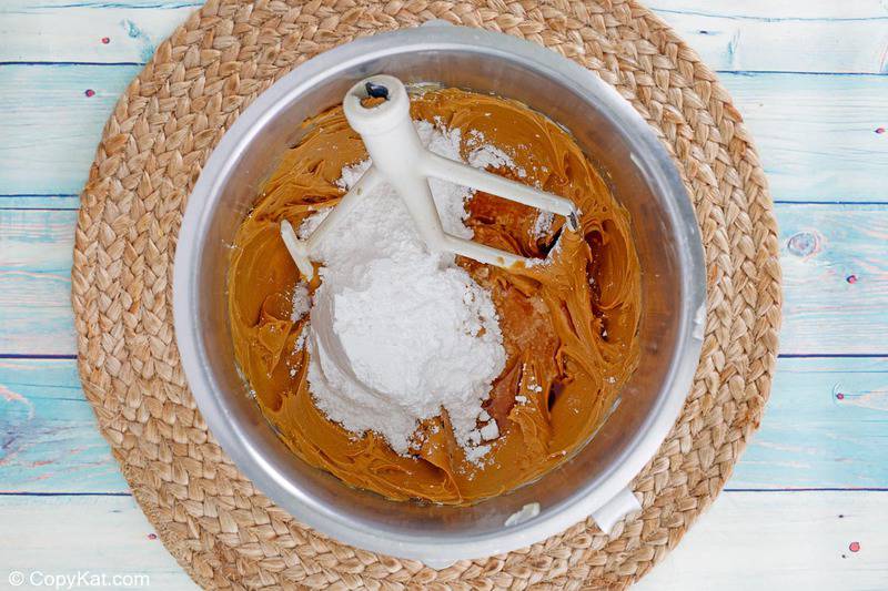 peanut butter frosting mixture and powdered sugar in a mixing bowl