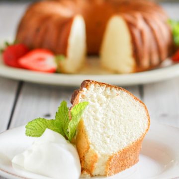 slice of Scandinavian almond cake on a plate in front of the cake
