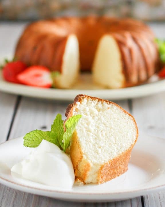 slice of Scandinavian almond cake on a plate in front of the cake