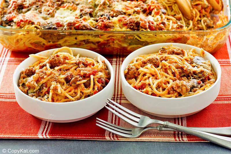 spaghetti casserole in two bowls and a baking dish