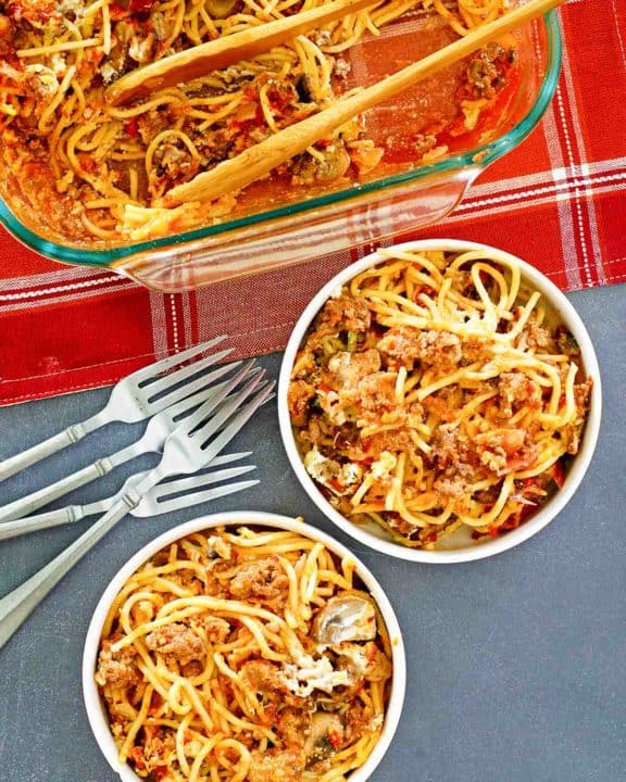 spaghetti casserole in a baking dish and two bowls
