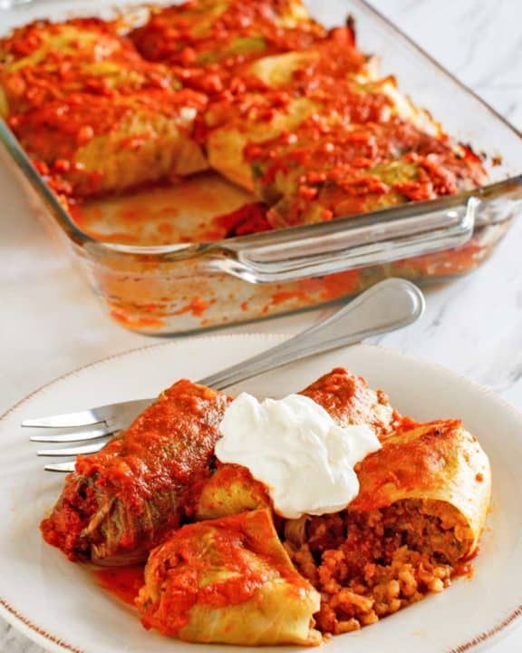 stuffed cabbage rolls in a baking dish and on a plate