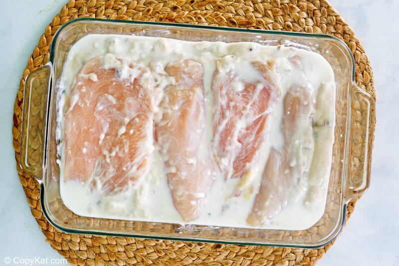 cream of mushroom soup and chicken breasts in a baking dish.