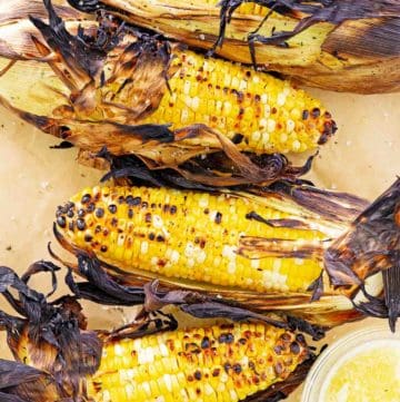 overhead view of grilled corn on the cob on parchment paper.