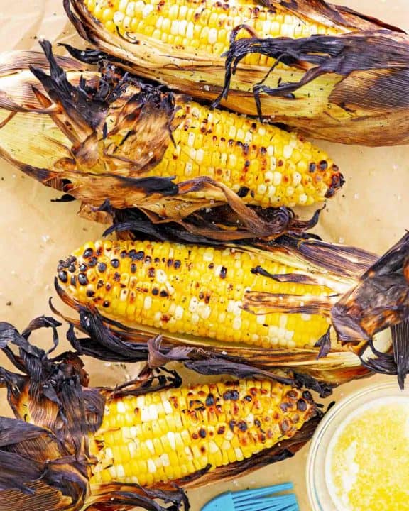 overhead view of grilled corn on the cob on parchment paper.