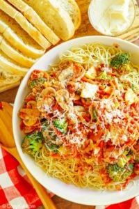 overhead view of homemade Olive Garden capellini primavera next to bread slices and butter