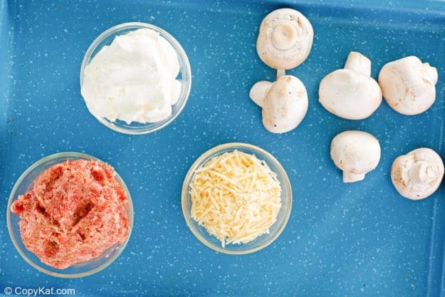 sausage stuffed mushrooms ingredients on a tray.