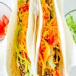 two homemade Taco Bell soft tacos with beef, lettuce, cheese, and tomatoes