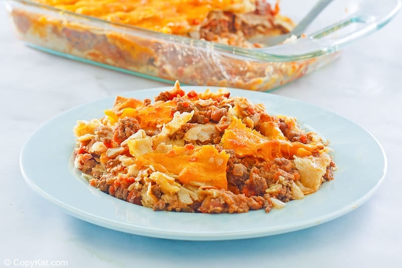 taco casserole on a light blue plate and in a glass baking dish