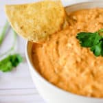 a bowl of taco dip and a tortilla chip.