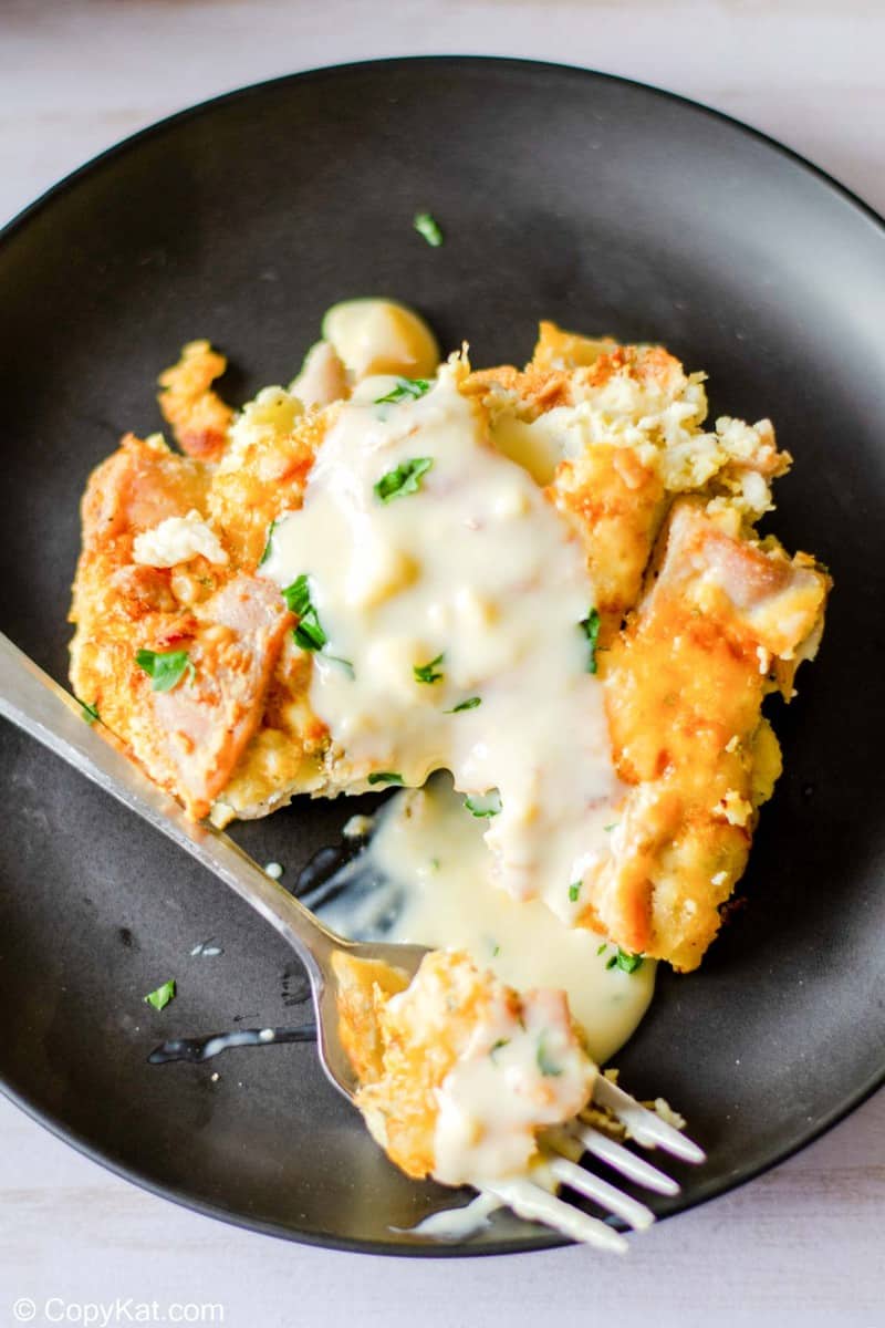 overhead view of a serving of tarragon chicken casserole with sauce on a plate.