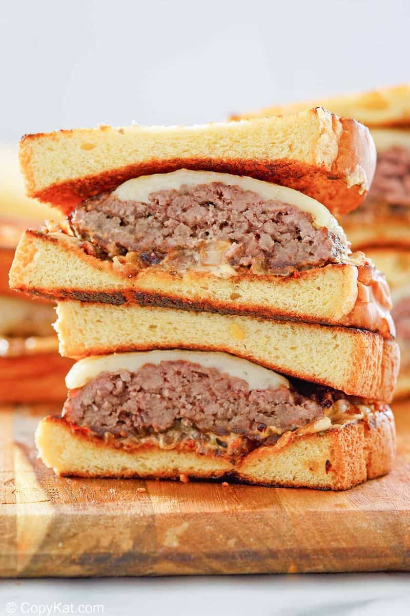 a homemade Whataburger patty melt sandwich on a wood cutting board