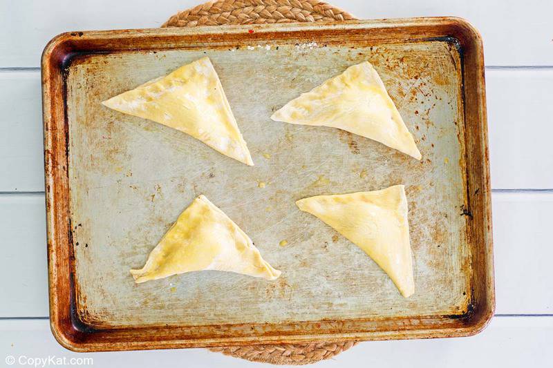 cherry turnovers on a baking sheet before being baked
